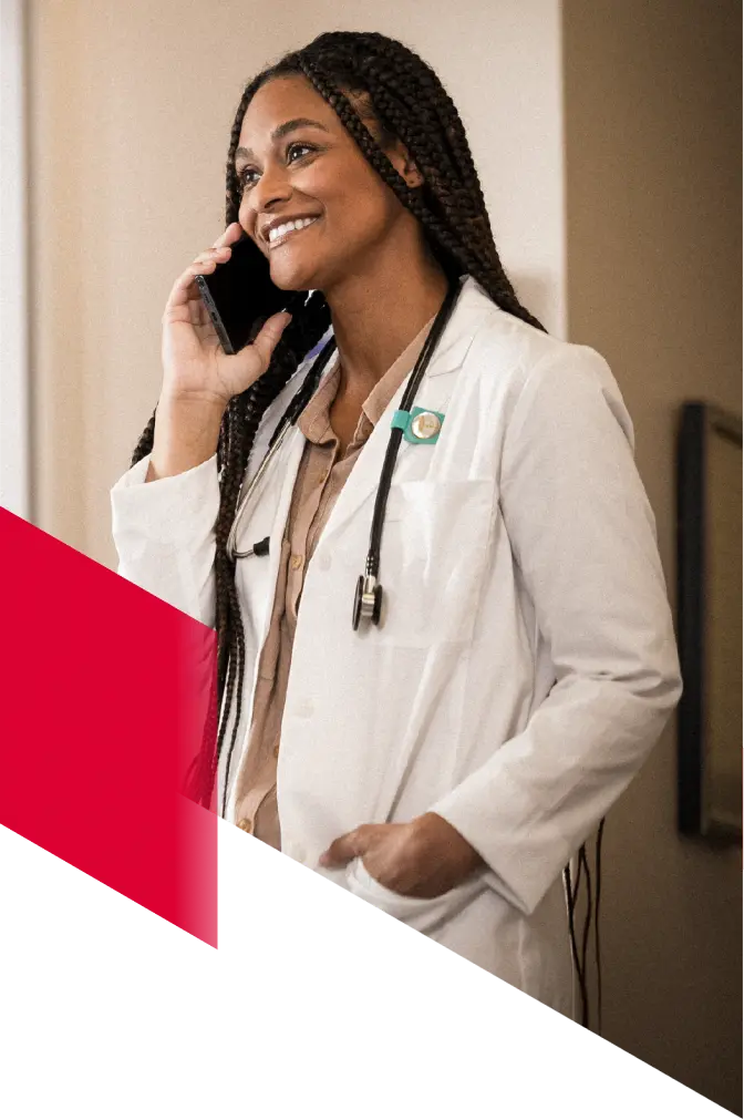 A locums physician at work takes a call and smiles.